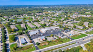 Aerial Exterior of Acclaim at Hinsdale Lake, lush foliage, countless residential buildings, body of water inside the property.