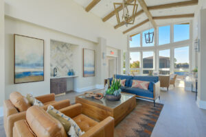 Interior Clubhouse, Contemporary rustic decor, leather lounge chairs, high ceilings, view of pool area, abstract art on the walls, wood floors, neutral toned walls.